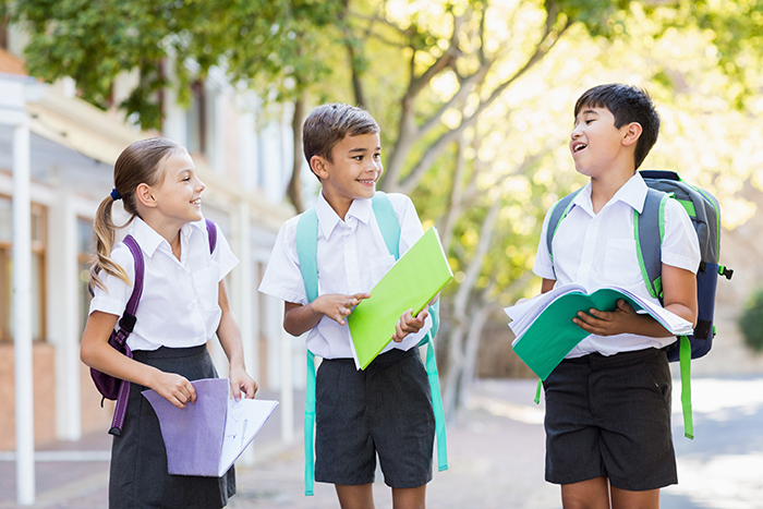 School kids talking to each other while reading books in campus 748968